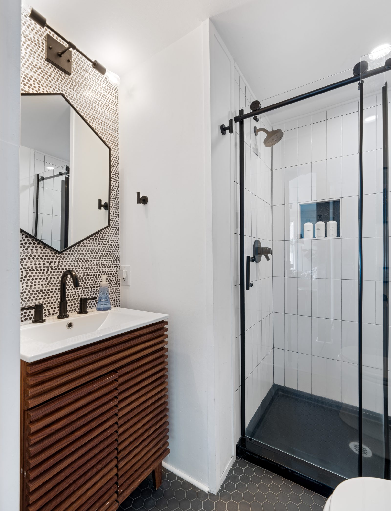 Walk-in shower with glass door and hexagonal tile